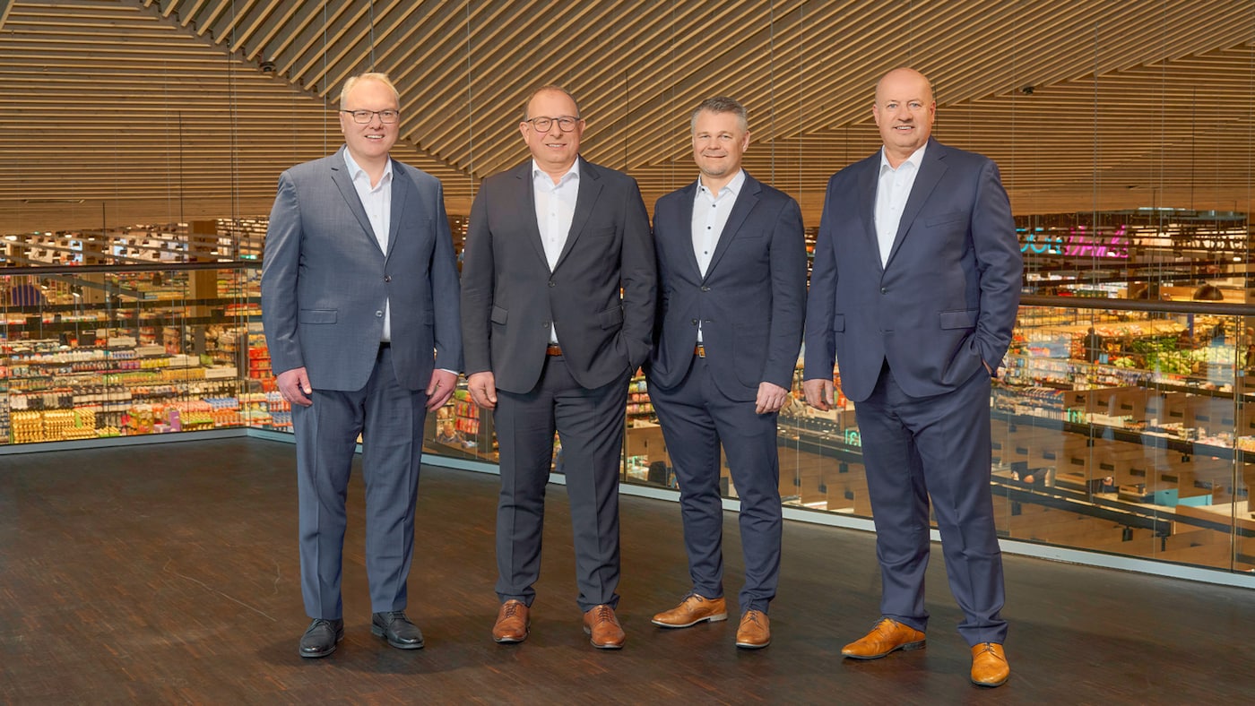 Gruppenfoto des vierköpfigen Vorstands von EDEKA Südwest im Innern einer Supermarkthalle.
